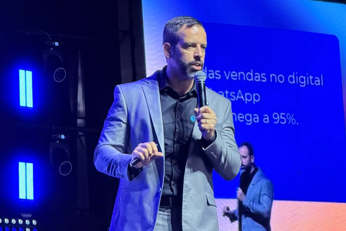 Rafael Tonietto palestrando sobre vendas no digital, com o telão da apresentação ao fundo